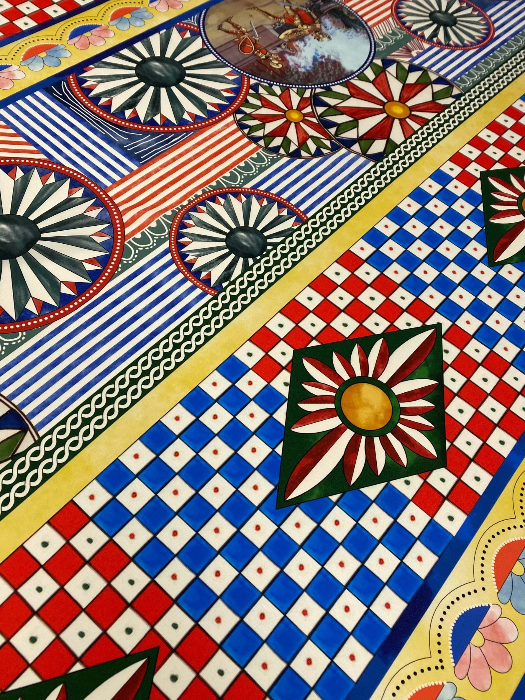 Sicilian Caretto Pattern Fabric with vibrant geometric and floral designs in red, blue, yellow, and green colors.