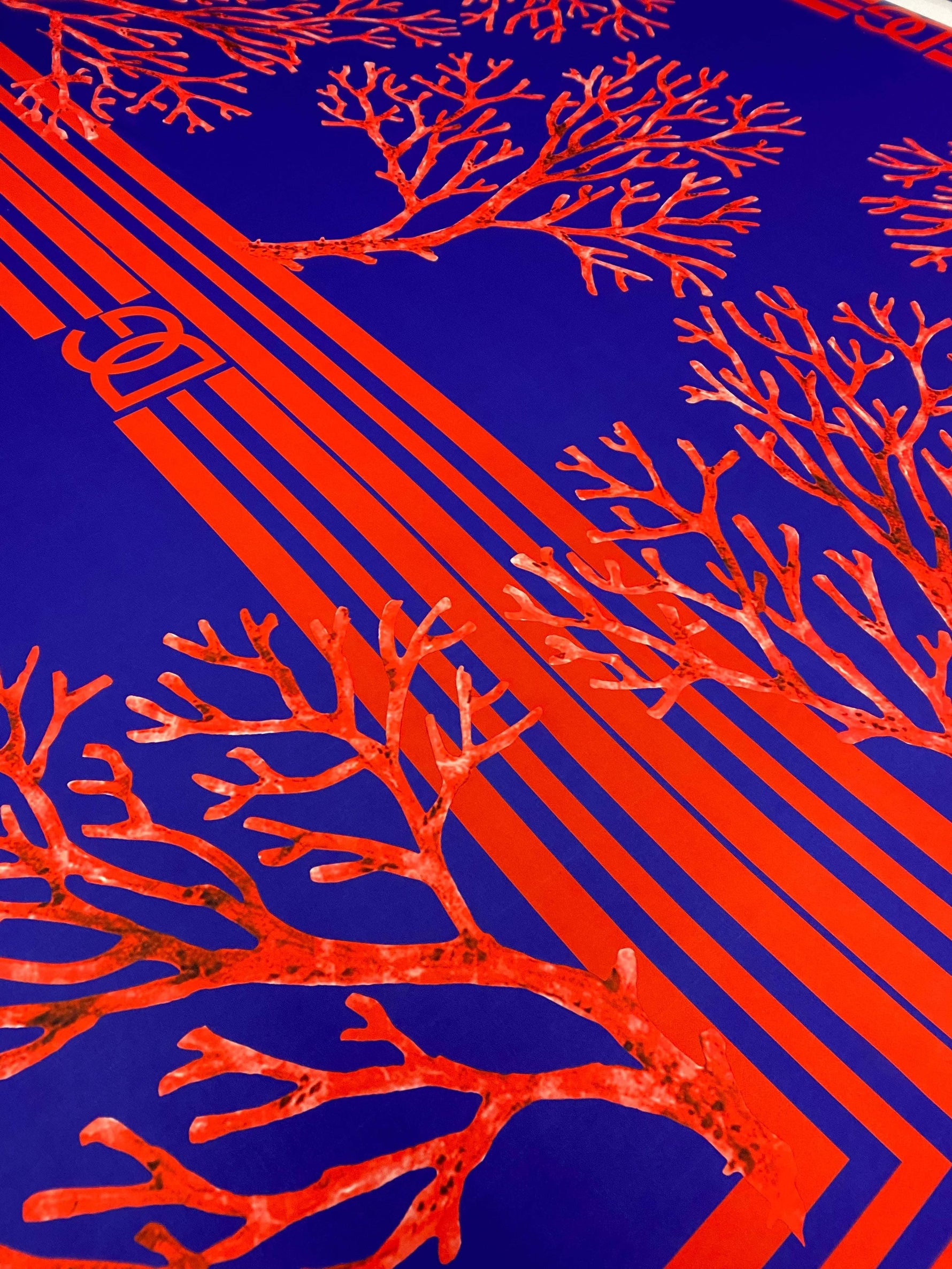 Red coral pattern on navy blue fabric panel with geometric stripes for sewing and crafts