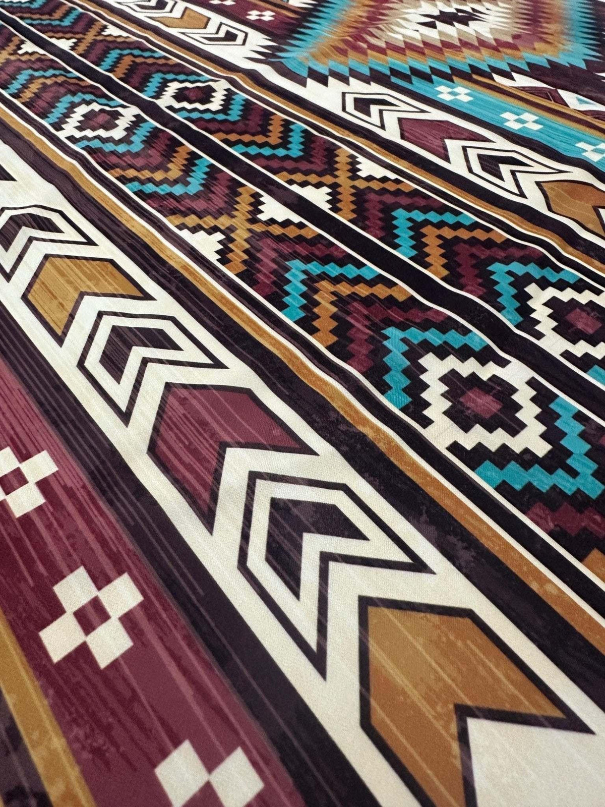 Aztec Retro Southwest Fabric with colorful geometric southwestern patterns in teal, purple, brown, and white, ideal for apparel and home decor projects