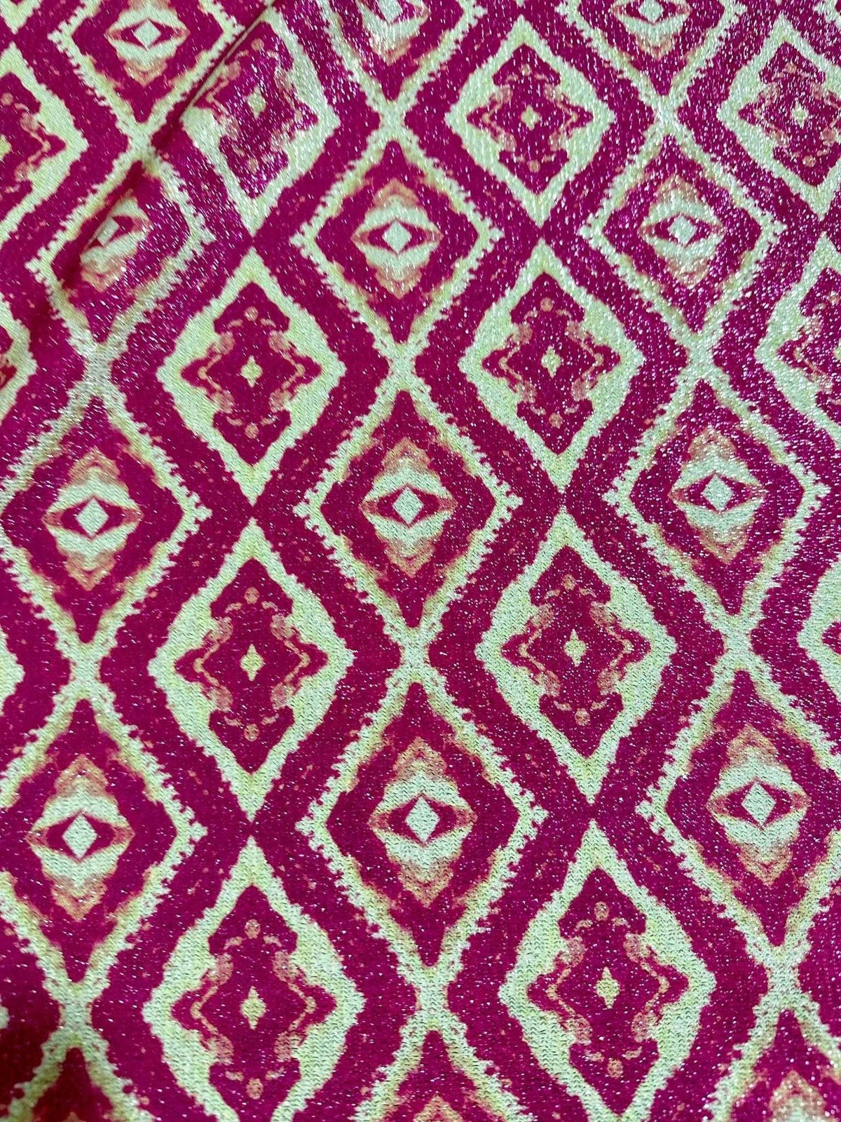 Close-up of Aztec Lurex Knit Fabric with pink and gold shimmering diamond pattern and 4-way stretch texture
