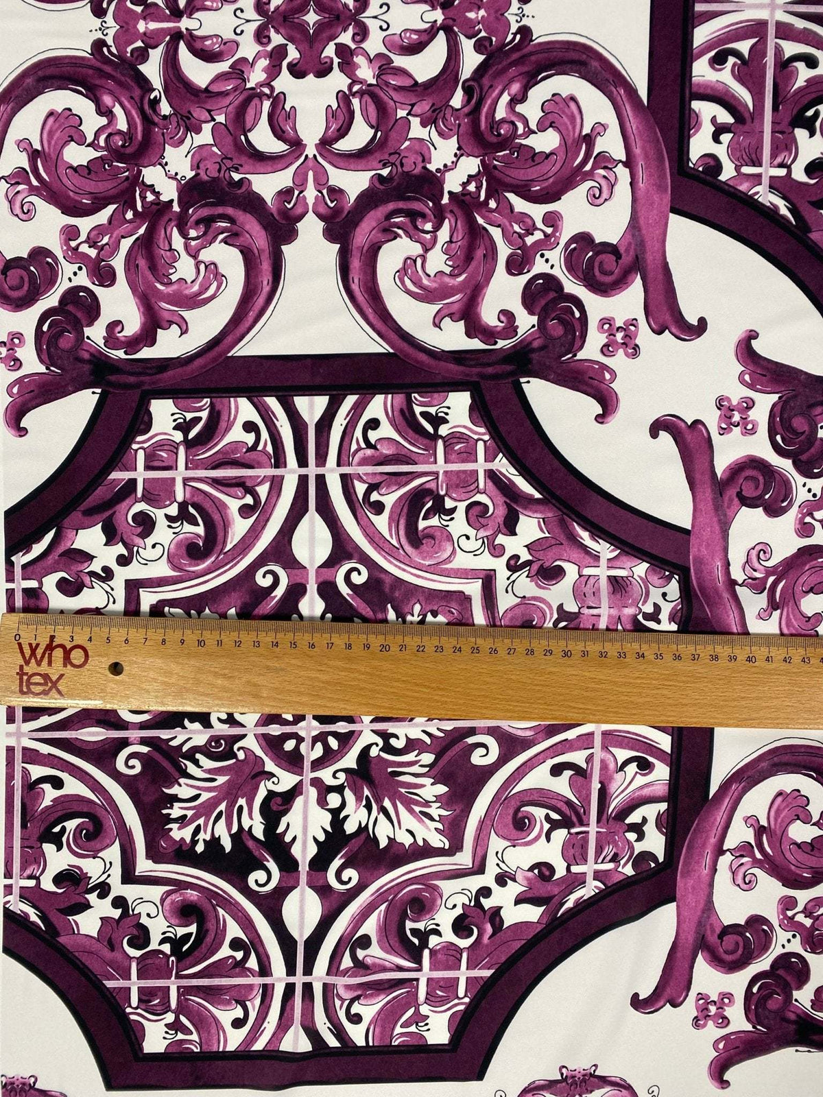 Baroque style purple ornamental print fabric with intricate design and ruler for scale