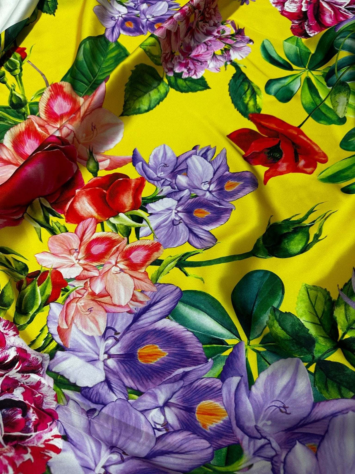 Bright yellow rose floral fabric with large colorful flowers and green leaves on vibrant yellow background