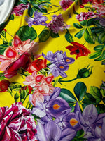 Bright yellow fabric with large colorful rose and floral patterns for fashion and home decor