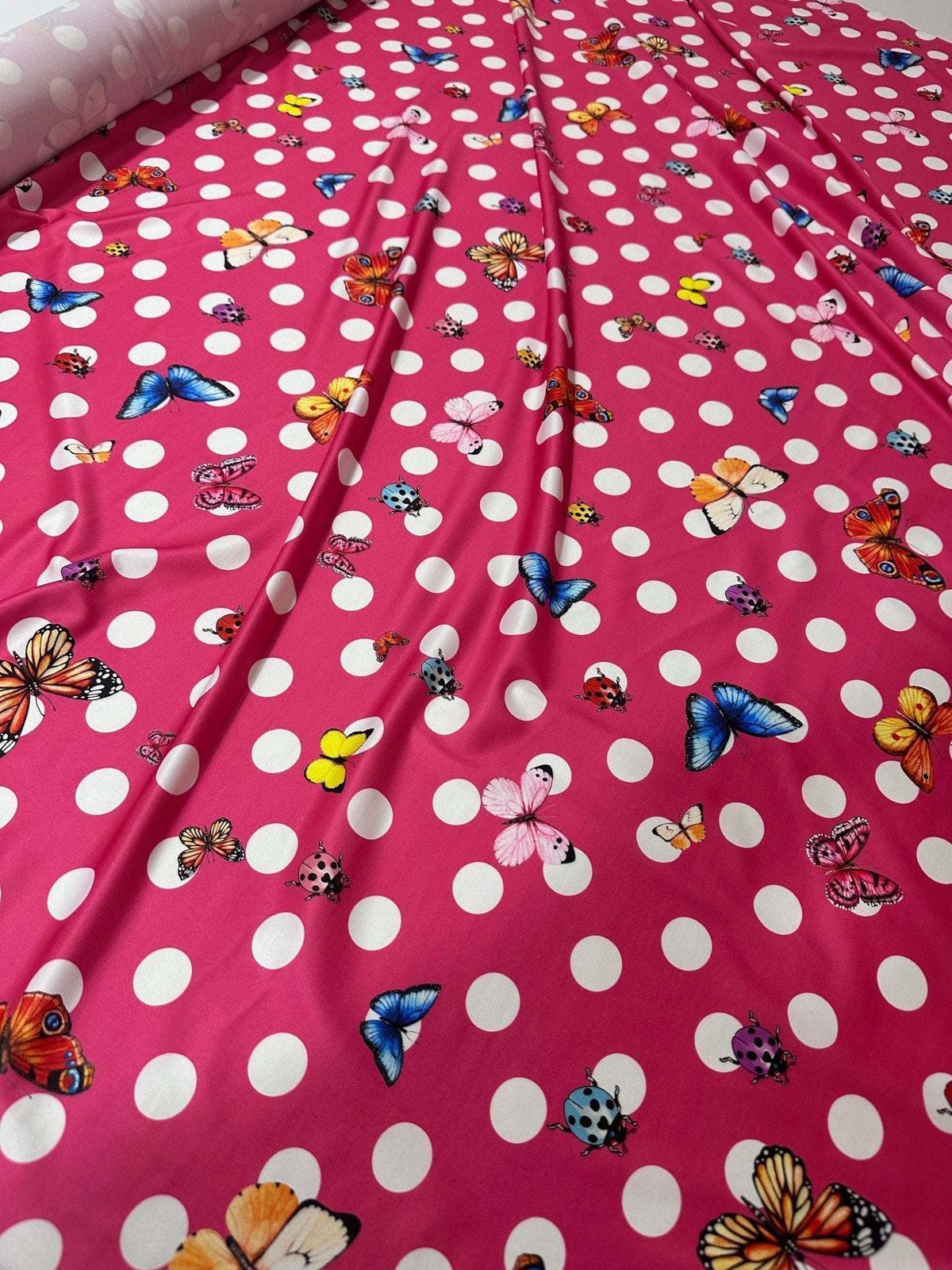 Bright pink butterfly polka dot fabric with colorful butterfly and white dot pattern for sewing and crafts