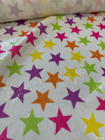 Close-up of colorful stars sequin fabric with 2-way stretch on white background for fashion use