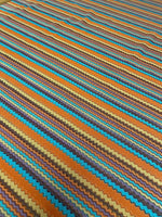 Colorful zigzag stripe knit fabric with vibrant green, orange, blue, and brown tones in a continuous pattern