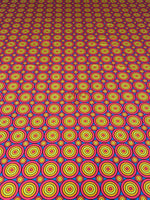 Colorful geometric circles print fabric with bright concentric circle patterns in yellow, red, and blue tones, perfect for sewing projects.