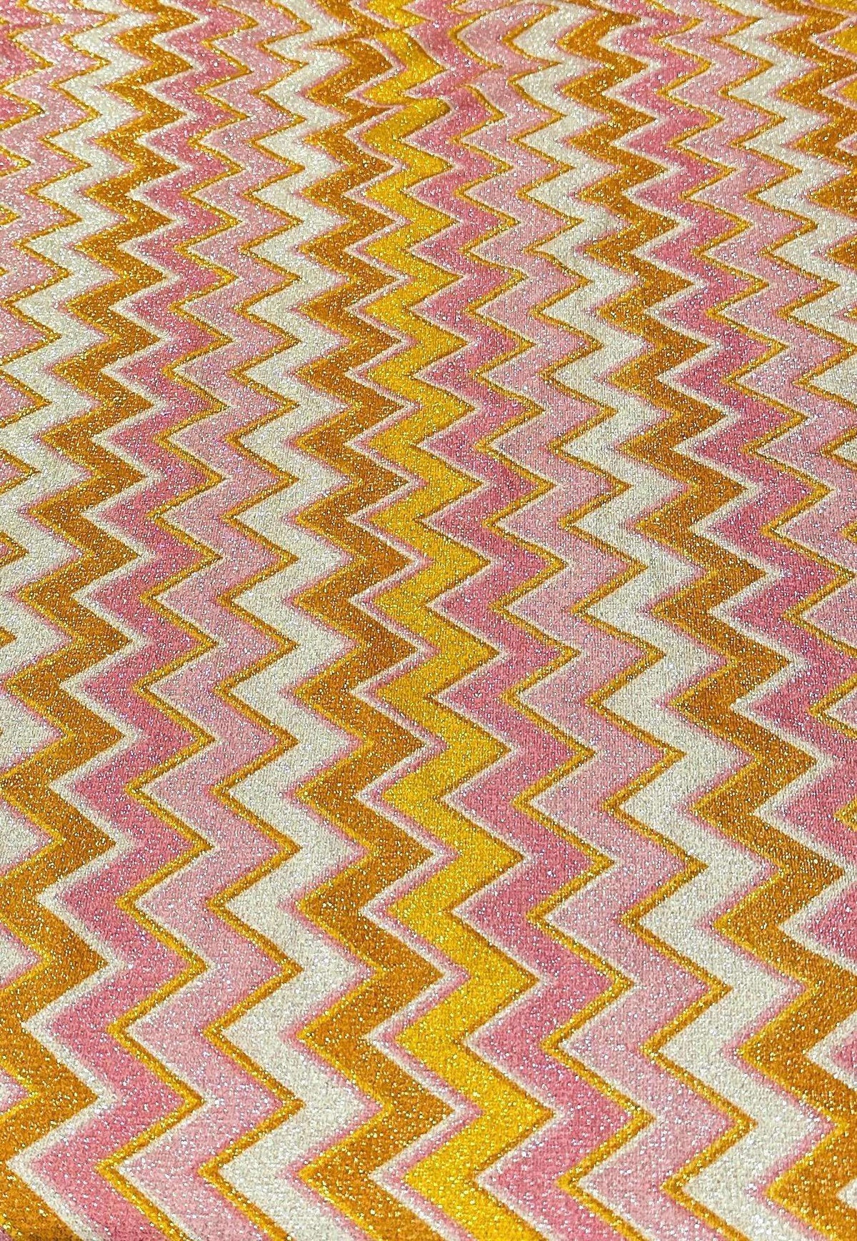 Pink orange zigzag glitter stretch fabric with gold Lurex threads and vibrant zigzag pattern