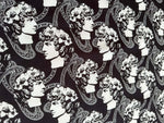 Black and white Greek crepe fabric featuring repeated classical Roman profile designs and intricate patterns