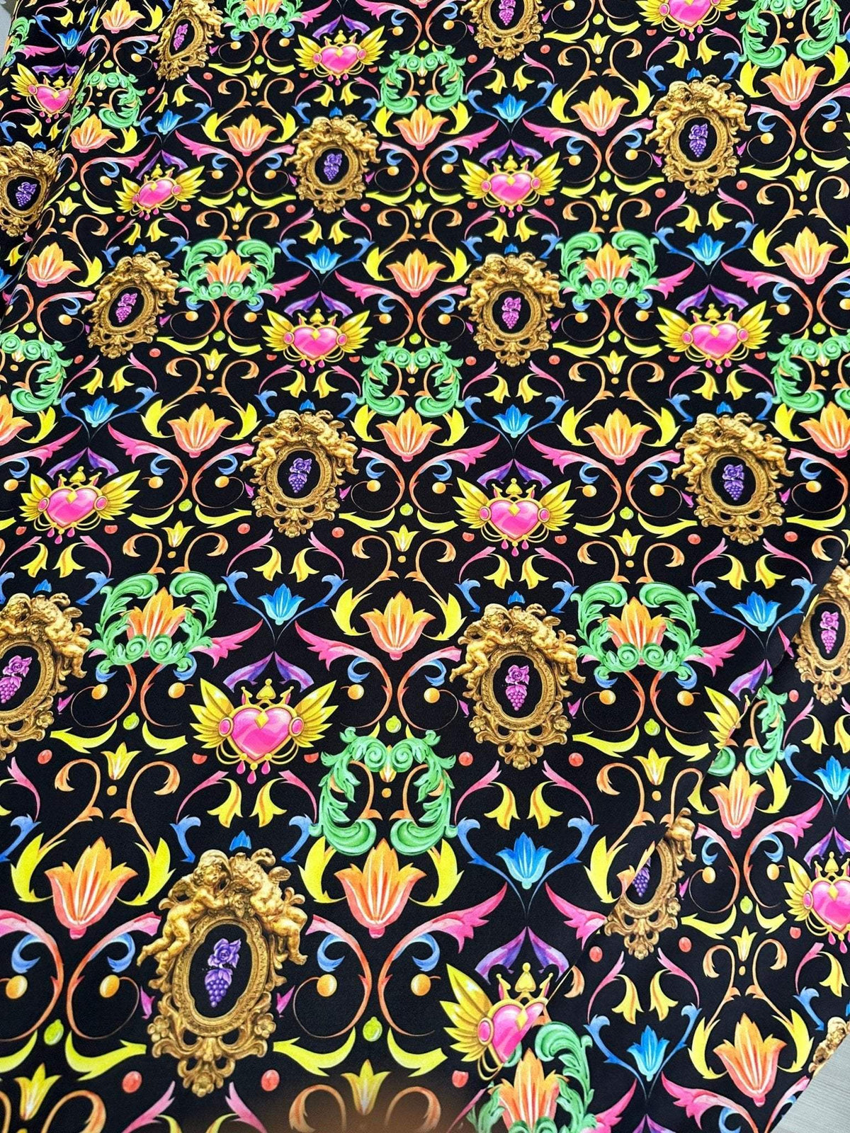 Vibrant black fabric with colorful baroque floral heart pattern design
