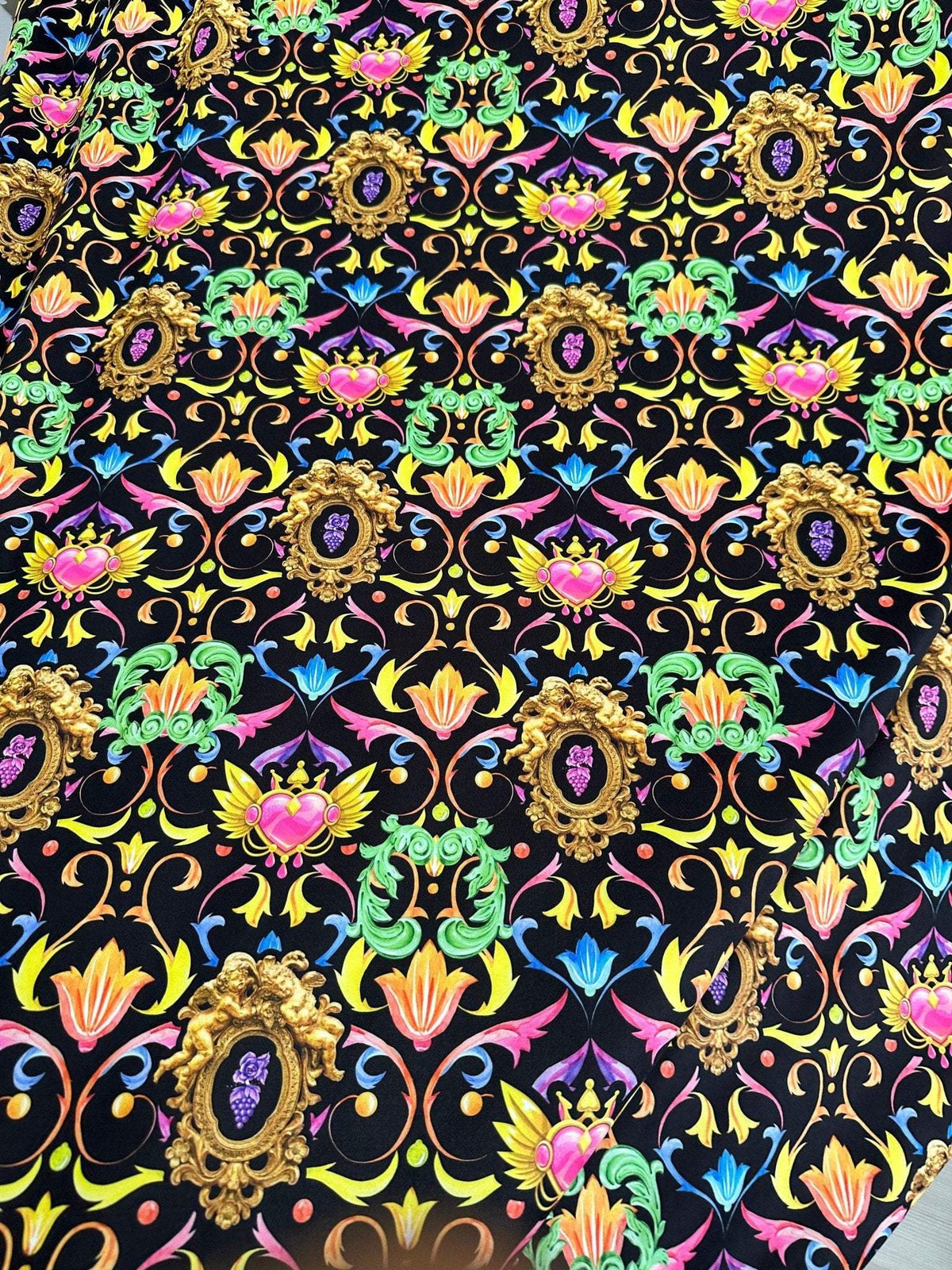 Vibrant black fabric with colorful baroque floral heart pattern and ornate gold frames