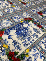 Majolica mosaic pattern Italian tile fabric with blue intricate designs, red roses, and yellow lemons on a white background