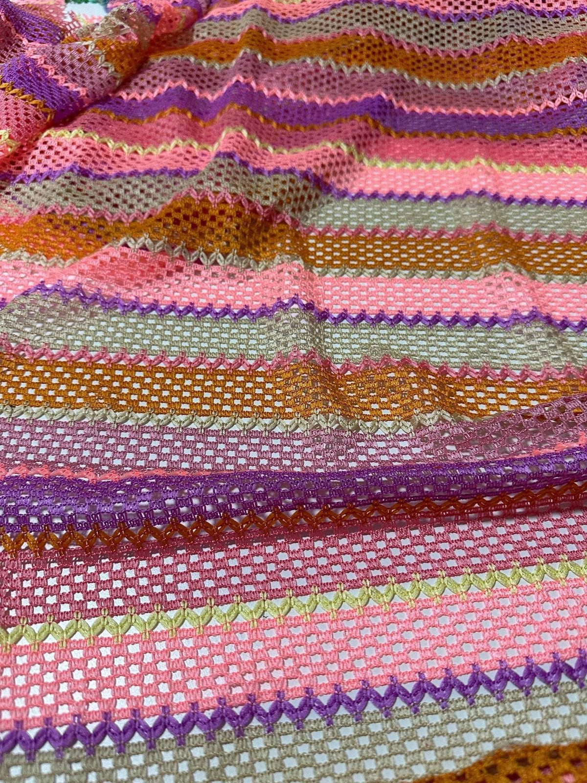 Pink striped knit jersey fabric with vibrant mesh texture and multicolor horizontal stripes