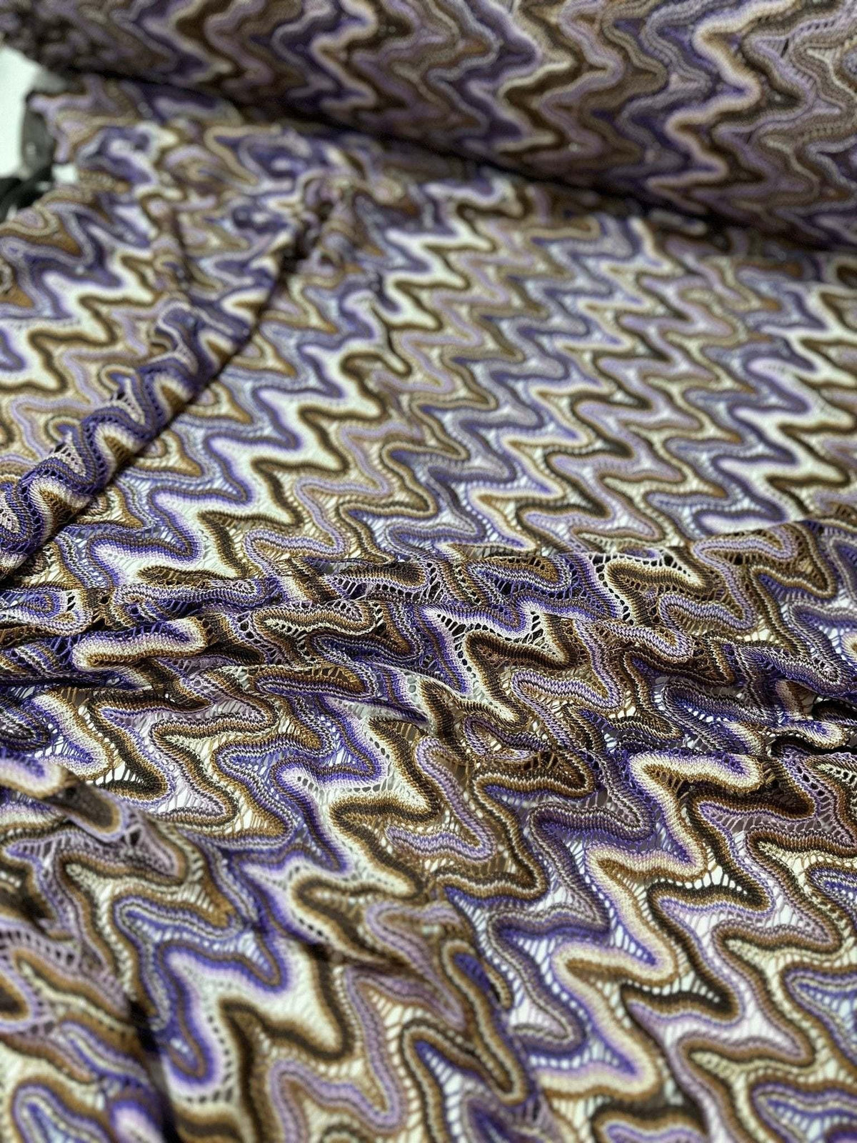 close-up of purple brown zigzag knit jersey mesh fabric with wavy pattern and texture