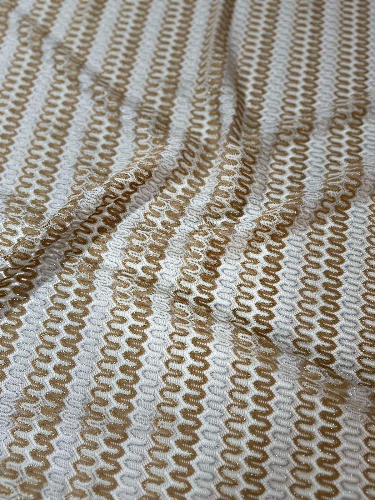 Soft beige and cream shimmer zigzag knit jersey fabric with chevron pattern and lightweight texture