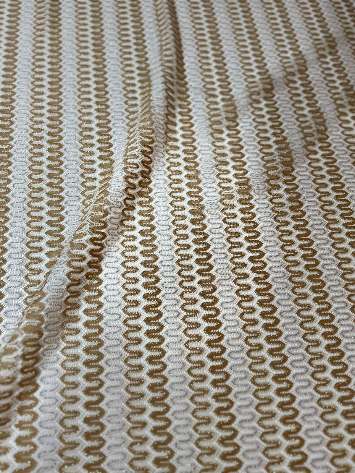 Shimmer zigzag knit jersey fabric in soft beige and cream chevron pattern with a lightweight, breathable texture.