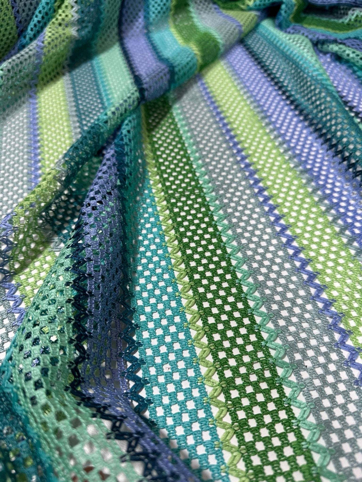 Striped knit mesh fabric with green, blue, and purple zigzag patterns for creative sewing projects