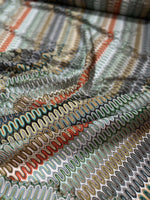 Close-up of colorful Mesh Zigzag Knit jersey fabric with wavy zigzag pattern and soft texture.