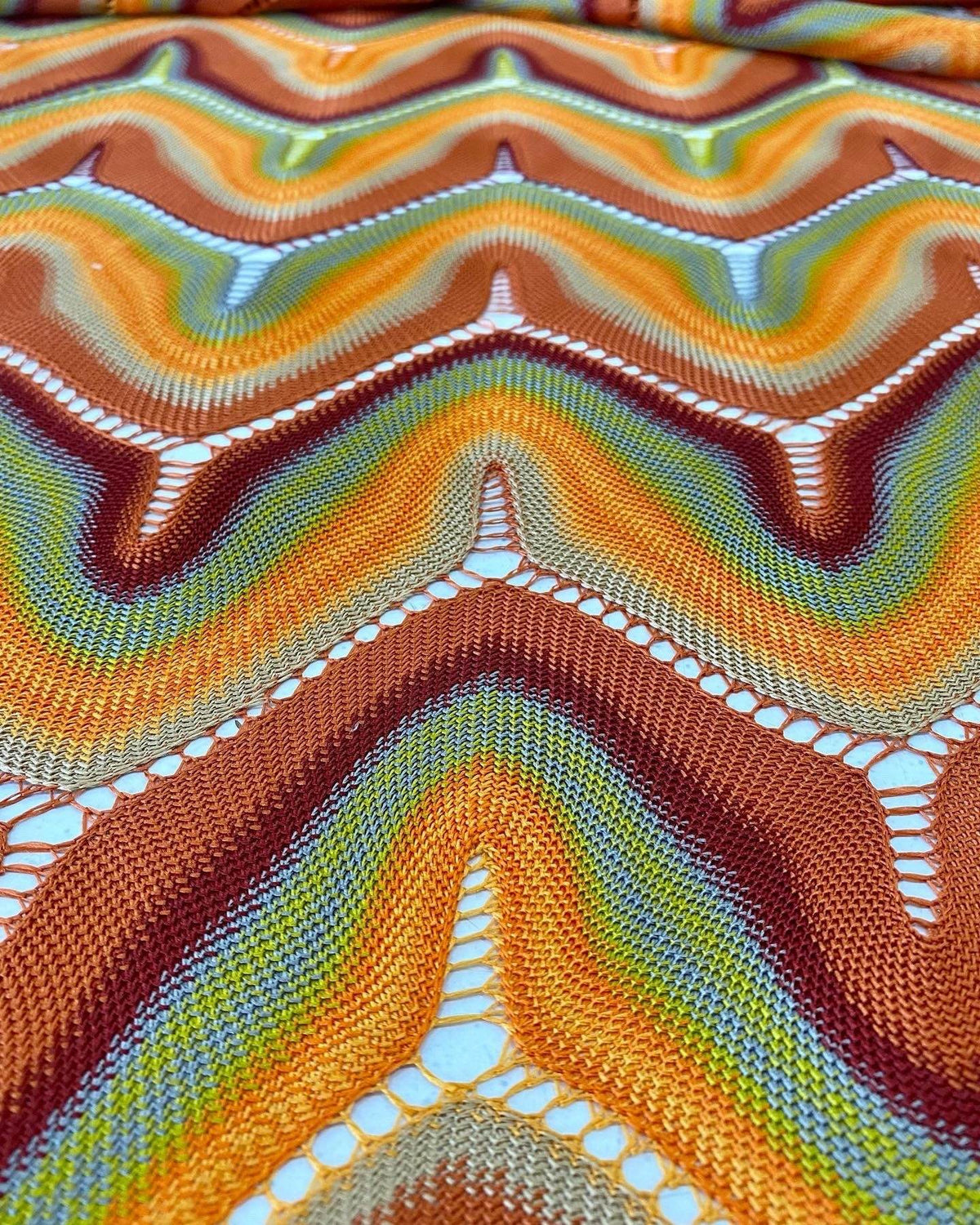 Zigzag Knit Jersey Mesh Fabric with colorful chevron pattern and open mesh details in warm tones for fashion and craft projects