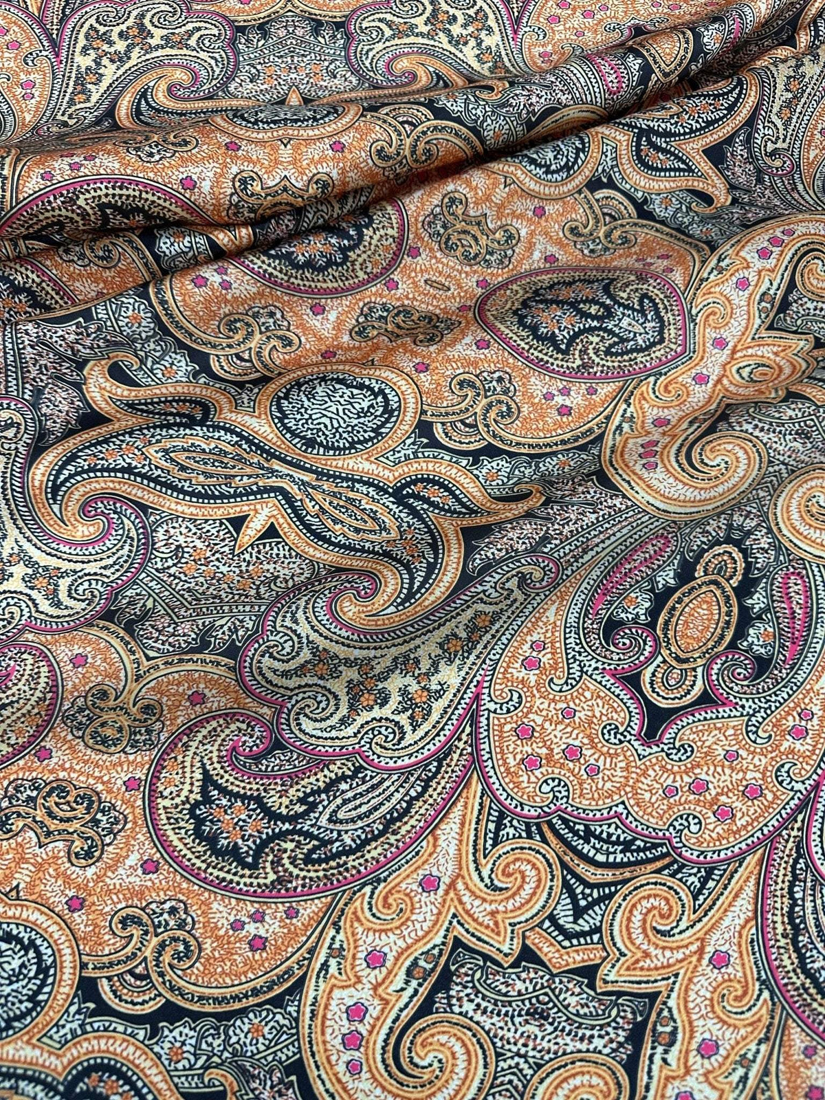 Black and orange paisley patterned fabric with intricate decorative design and 150cm width