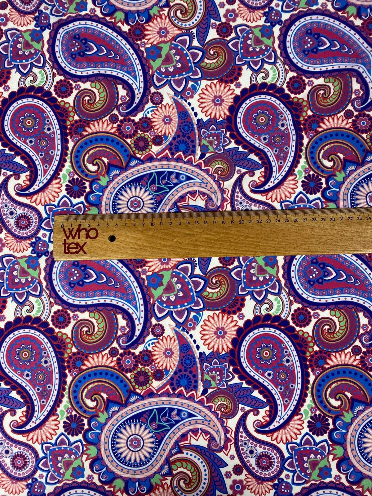 Purple paisley upholstery fabric with intricate digital print featuring blue, red, and green paisley and floral patterns.