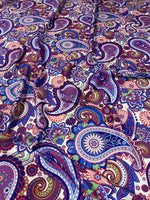 Purple paisley fabric with intricate multicolored digital print, ideal for upholstery and home decor projects.