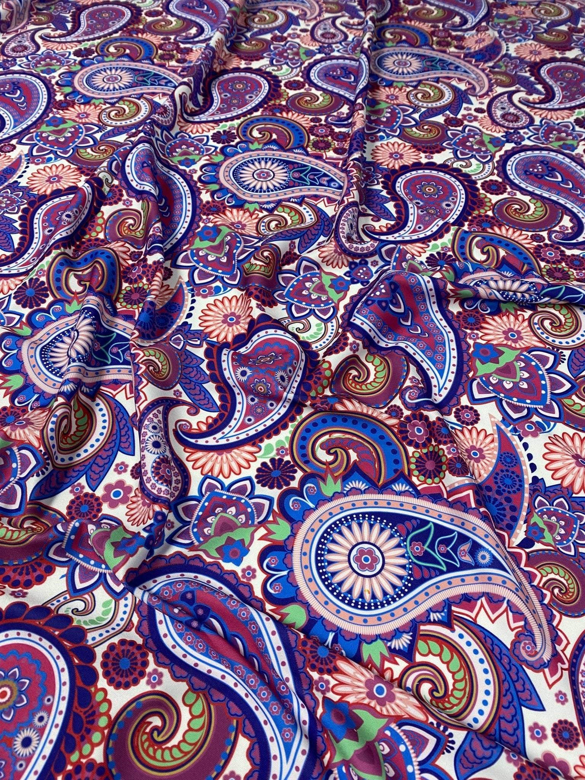 Purple paisley fabric with intricate multicolored digital print, ideal for upholstery and home decor projects.