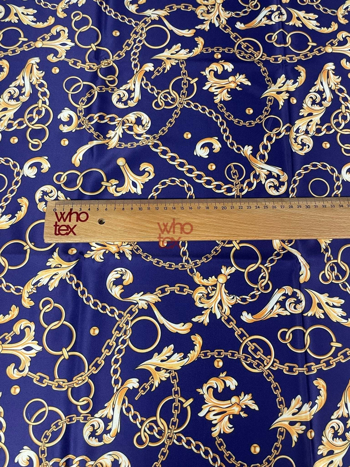 Royal blue fabric with gold chains and baroque scrolls pattern and ruler for scale