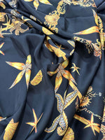 Black luxury fabric with intricate golden sea shell and starfish pattern on a black background