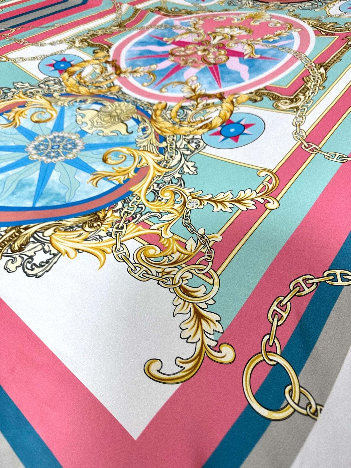 Baroque chain pattern fabric with ornate gold designs and multicolor accents on pink and blue background