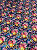 Close-up of vibrant tiny floral design upholstery fabric with pink and yellow flowers on a dark blue background