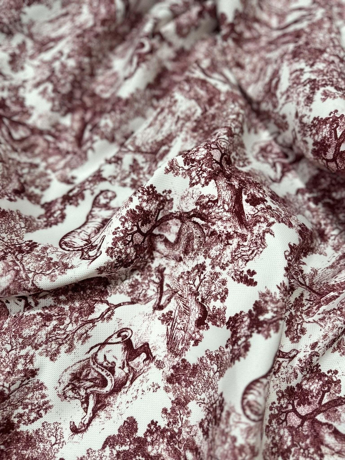 Brown wild forest pattern fabric with white background and animal motifs in Bordeaux shade, ideal for sewing and home decor projects