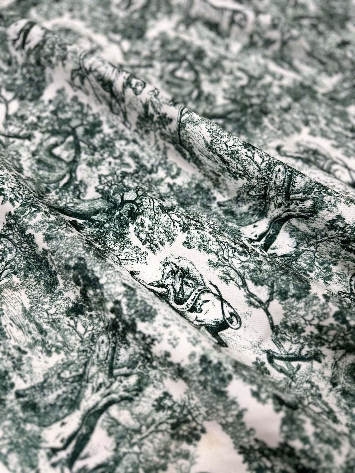 Green and white wild forest animal print fabric with detailed nature-inspired design for sewing and home decor projects