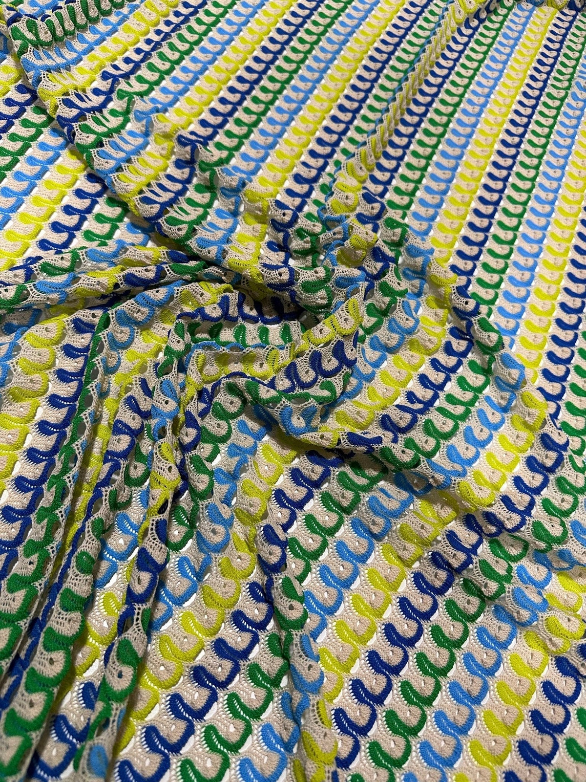 Luxury zigzag knit jersey fabric with blue, yellow, and green chevron pattern close-up